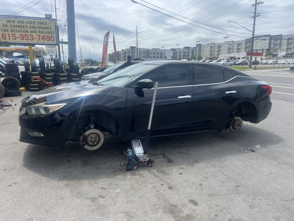 Black Nissan Maxima lifted for tire and rim installation at Titan Tire & Wheels in Nashville
