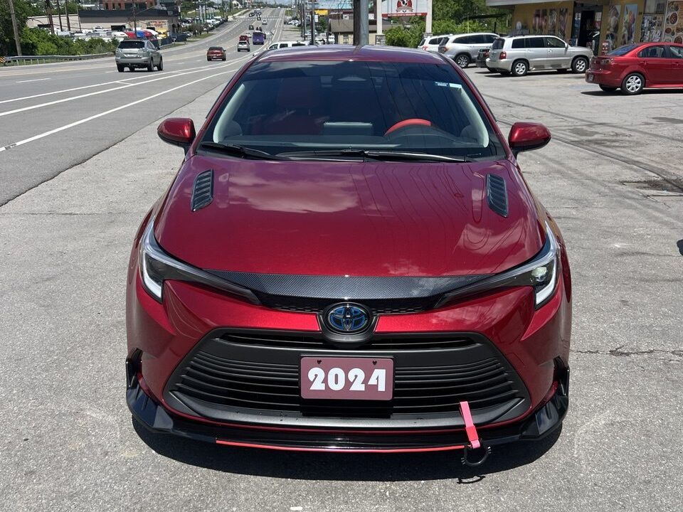 Frontal shot of a customized 2021 Toyota Corolla on the roadside in front of Rivergate Supermercado.